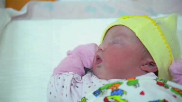 Новорожденный младенец спит в одеяле в родильной комнате, девочка плачет сразу после рождения — стоковое видео