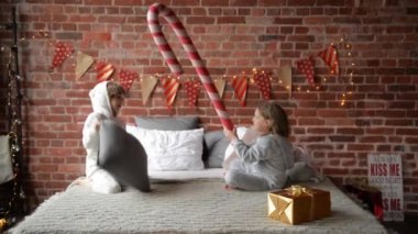Birlikte Noel sabahı, mutlu Noeller oynamak kardeş evde, yastık ile mücadele sıcak xmas pijama oynak kardeşler