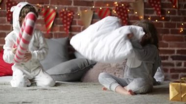 Birlikte Noel sabahı, mutlu Noeller oynamak kardeş evde, yastık ile mücadele sıcak xmas pijama oynak kardeşler