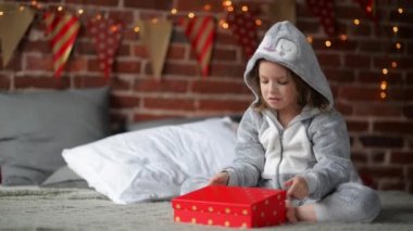 Sevimli küçük kız mutsuz Noel hediyesini tarafından bir onu bir şömine ile yatak Noel sabahı