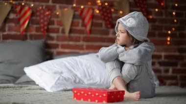 Sevimli küçük kız mutsuz Noel hediyesini tarafından bir onu bir şömine ile yatak Noel sabahı