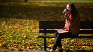 Oldukça Kafkas kadın kahve içme ve açık gevşeme kavramı sonbahar parkta bankta okuma