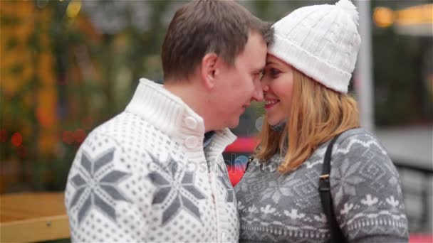 Feliz joven pareja divirtiéndose en la feria de Navidad, pareja enamorada besándose al aire libre. Feliz Navidad y Feliz Año Nuevo — Vídeos de Stock