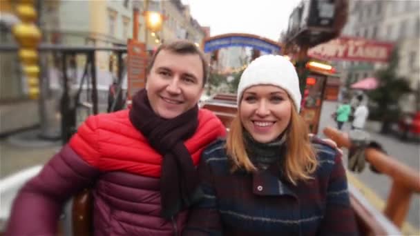 Lachende Paare, die sich an der Attraktion auf dem Weihnachtsmarkt amüsieren, junge Familien, die auf dem Weihnachtsmarkt lachen. Frohe Weihnachten und ein gutes neues Jahr — Stockvideo