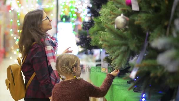 Albero di natale di scelta del bambino e della madre al supermercato ... Albero di natale con mensole