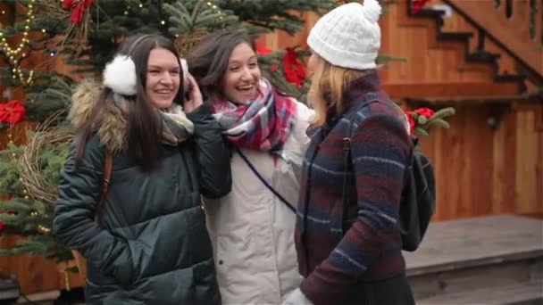 Šťastné setkání tří přátel objímání Cristmas trhu, směje se přítelkyně baví na vánoční trhu. Veselé Vánoce a šťastný nový rok — Stock video