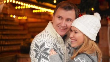 Mutlu genç çift birlikte sıcak giysiler, Noel şenlikli arka plan, Aile Xmas piyasada gülüyor, tüyler ürpertici. Mutlu Noeller ve mutlu yeni yıl