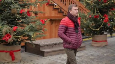 Genç adam onun Girldriend bir tarih ve saat at Looking için bekliyor. Güzel kadın gelir bir ona erkek ve Hugging. Mutlu Noeller ve mutlu yeni yıl