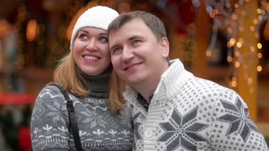 Neşeli mutlu genç eğleniyor ve Noel piyasada öpüşme çift. Erkek ve kadın geçirdiği zaman birlikte Xmas piyasada. Mutlu Noeller ve mutlu yeni yıl