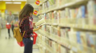 Kitap süpermarkette onun elinde tutan gözlük ile zeki güzel kız. Sevimli kadın bir Tome bir başlangıç rafı alır ve başka bir arama geri koyar.