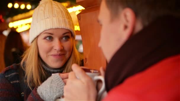 Ładna kobieta z biały kapelusz i rękawiczki szary o gorący napój i rozmawia z przystojny Man. szczęśliwa para w ciepłe ubrania picie kawy na Street Cafe. — Wideo stockowe