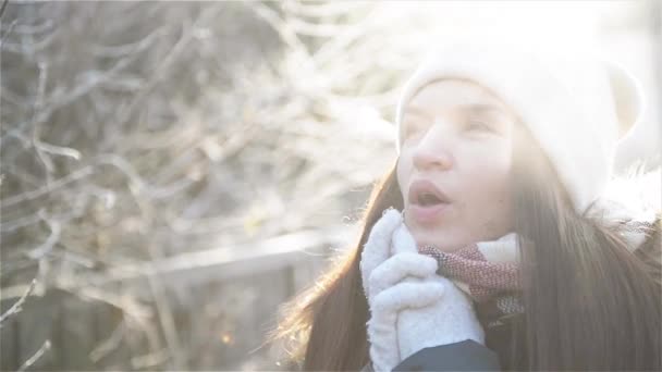 Bella donna cercando di riscaldare le sue mani congelate con un respiro in inverno mattina all'aperto. incredibile ragazza con gelido respirazione godendo freddo soleggiato tempo nel parco . — Video Stock