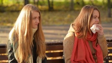 İki güzel kız sonbahar güneşli bir günde sırasında parkta Fast Food yeme. Öğrenciler üzerinde tezgah açık havada oturup Öğle Yemeği.