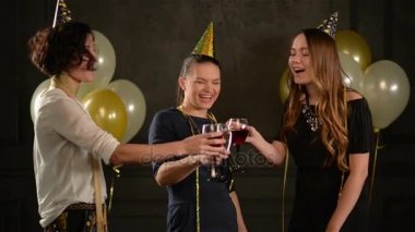 Güzel kız arkadaşları ile bir doğum günü tebrik. Üç bardak şampanya ve şarap birlikte bir partide eğleniyor kadınlarla hava balonları arka plan üzerinde.