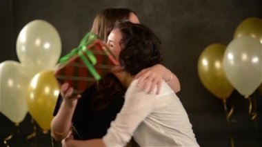 Grup arkadaşıyla birlikte bir sürpriz yapma onun üç kutu vererek uzun saçlı şaşırtıcı Bayan için mevcut. Doğum günü kızı hediyeler elinde tutan gülümseyerek.