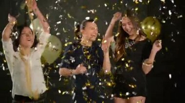 Güzel çılgın kızlar altın ve gümüş konfeti arasında o Falling Down dans ediyor. Eğlenceli birlikte sırasında disko parti üç güzel kadınlar.