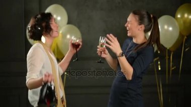 İki sevimli kız dans balonlar siyah zemin üzerine konfeti çevrili bulunmaktadır. Kıvırcık saçlı bir bayan bir bardağı ve kırmızı ayakkabıları düzenliyor. Başka bir kadına kadeh şampanya vardır.