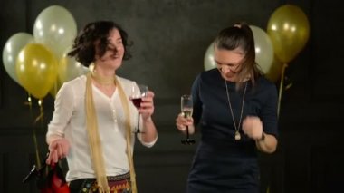 Gülen kadınlar zevk disko dans partisi ve içme alkol vardır. İki esmer birlikte Holding gözlük şarap ve şampanya ile dans.
