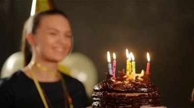 Şapkalı güzel Bayan Her doğum günü mumları çikolatalı kek ve Applauding dışarı üfleme olduğunu. Kadın kutlama çekici gülümseme ile.