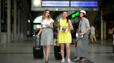 Bilet ve belgeleri elinde üç şaşırtıcı kız are seyir vasıl belgili tanımlık puan tahtası Havaalanı ve yatılı için oluyor onların uçak.