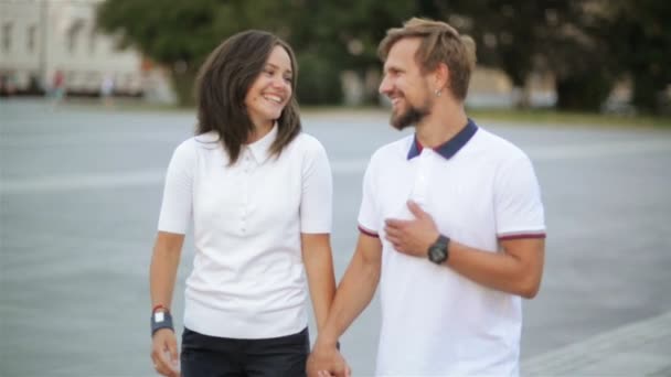 Skäggiga pojkvän och hans fantastiska brunett flickvän som promenerar runt i staden som håller hand. — Stockvideo