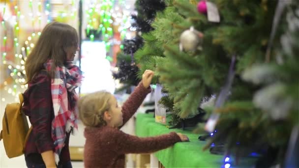 Albero di natale di scelta del bambino e della madre al supermercato ... Albero di natale con mensole