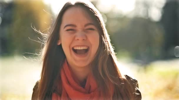 Glada unga vackra kvinnan skrattar och tittar i kameran, hösten Park bakgrund. Tidig höst i oktober. — Stockvideo