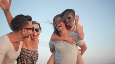 Açık havada Beach tatil keyfini arkadaşlar mutlu genç grup portresi. İki çiftler gülüyor yakınındaki deniz sırasında yaz saati.