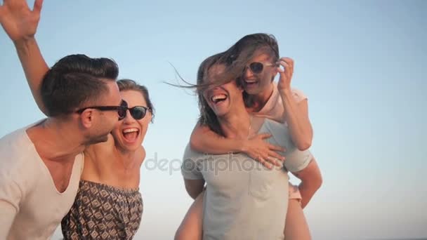 Porträt einer glücklichen jungen Gruppe von Freunden, die ihren Strandurlaub genießen. zwei Paare, die im Sommer am Meer lachen. — Stockvideo