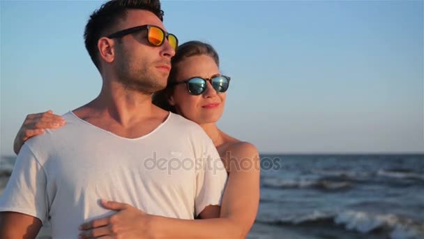 Geweldige Blonde knuffelen haar vriendje permanent op het strand in de buurt van de zee tijdens zonnige zomerdag. — Stockvideo