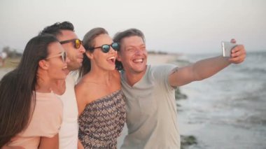 Açık havada Deniz rüzgarlı havalarda Selfie tarafından cep telefonu alarak iki portresi çiftler.