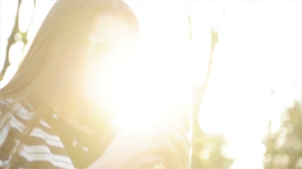 Portret van geweldige jonge vrouw met Smartphone en zonnebril buitenshuis. Mooie Brunette met behulp van haar mobiele telefoon met touchscreen permanent in het Park tijdens zonnige lente. — Stockvideo
