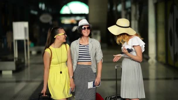 Tres chicas atractivas que viajan juntas durante las vacaciones de verano. Increíbles damas con boletos para un avión están de pie dentro del aeropuerto . — Vídeo de stock