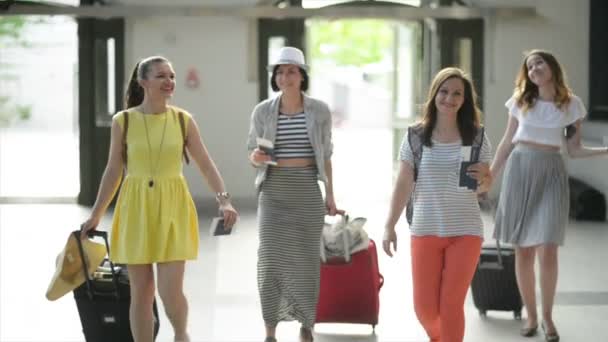 Atrakcyjne koleżanki idą do letnich podróży razem. Cute młodych kobiet są wejście przez drzwi lotniska z ich bagażu. — Wideo stockowe