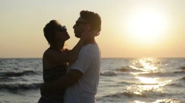 Yan görünümü, kontrast kaç sarılma deniz kenarında günbatımı sırasında sahilde.