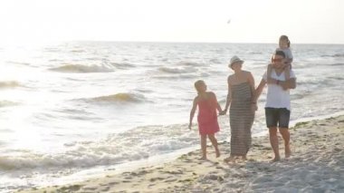 Mutlu gülümseyen aile yürüyüş birlikte deniz güneşli yaz günü sırasında yakın. İki çocukla vakit deniz güzel Çift.