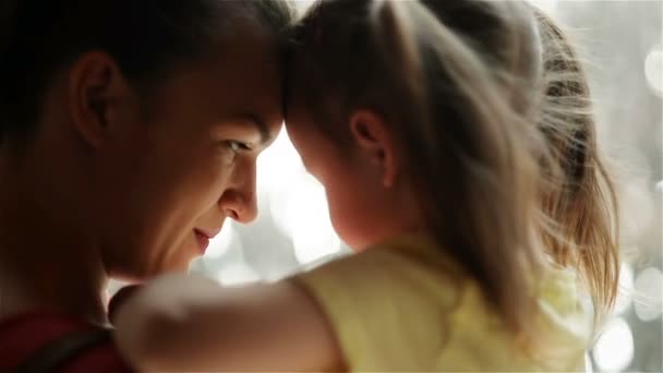 Mooie jonge moeder met haar dochter zijn knuffelen. Ze hebben een heleboel plezier samen. — Stockvideo