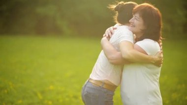 Mutlu anne ve kızı parkta. Aile açık hava yaşam tarzı ile güzellik doğa sahne. Birlikte yeşil çimenlerin üzerinde dinlenme ve Having Fun açık mutlu bir aile. Mutluluk ve uyum içinde aile hayatı.