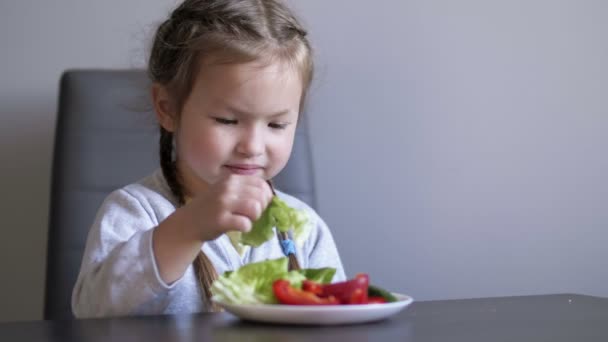 Gemüse essen will das kleine Mädchen nicht. Kind wird wütend und schiebt den Teller zur Seite — Stockvideo