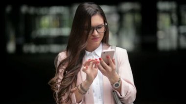 Mutlu Iş kadın sokakta duran bir akıllı telefon kullanır. Iyi haberler alıyor. Telefon konuşma