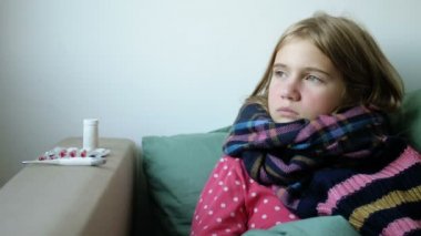 Sıcak eşarplı küçük kız burnunu siliyor. Rhinitis ve öksürük hastası çocuk.