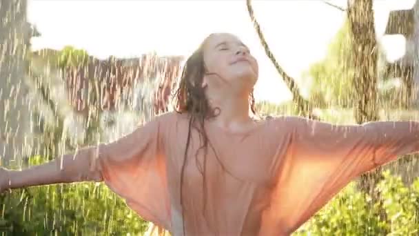 Jovem menina feliz se divertindo sob chuva. Sorrindo Miúdo molhado Sorria e tenha bom humor ao ar livre . — Vídeo de Stock