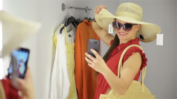 Šťastná mladá žena stojící v zkušebna v obchod s oblečením. Dívka se vyfotit u šatny — Stock video