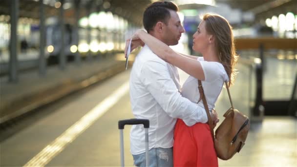 Triest jonge man verliefd strelen en afscheid te nemen van zijn vriendin in het trein station voordat vertrek op zonnige dag. — Stockvideo