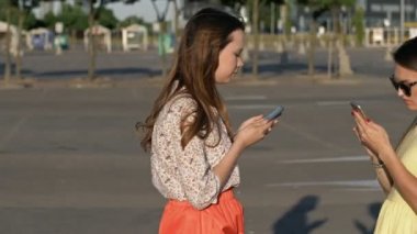 Sokakta yürüyen genç kadınlar akıllı telefonlarına bakıp birbirlerini görmezden geliyor ve çarpışıyor. Sosyal ağlara bağımlı. Antisosyal milenyumlar, teknoloji ve iletişim