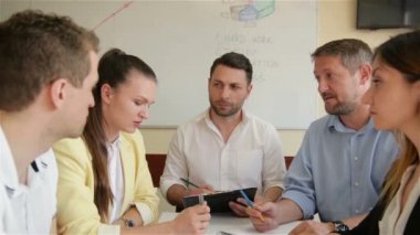 Ofiste Kurumsal İş Ekibi Çalışma Toplantısı. Beş Kafkas İşadamı ve İş kadını Grubu Birlikte Strateji Konuşuyor. İşbirliği, Büyüme, Başarı Kavramı Grafik Kullanma.