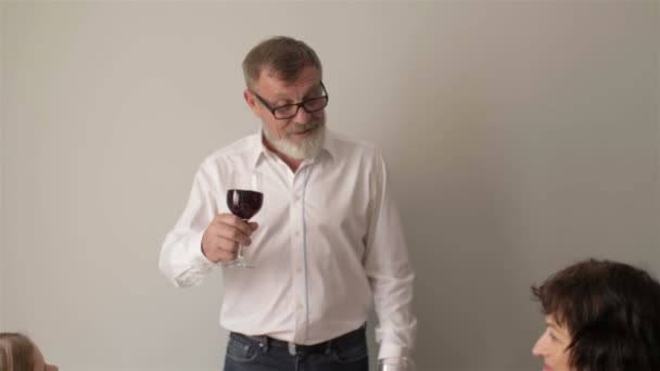 Familie zit rond een tafel, eten, communiceren en plezier hebben tijdens het familiediner. Familie toasten aan tafel thuis — Stockvideo