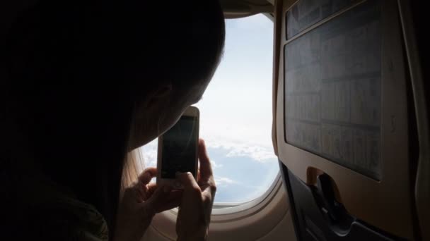 Mujer tomando una foto con smartphone en avión.Ideas de viaje y concepto de viaje — Vídeo de stock