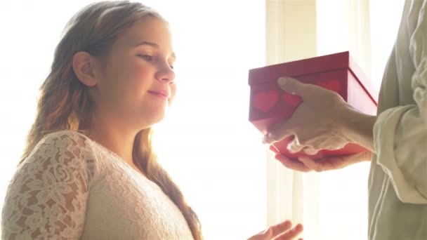 Liten söt flicka ler ger presentförpackning till lycklig mamma, grattis, firar mors dag — Stockvideo