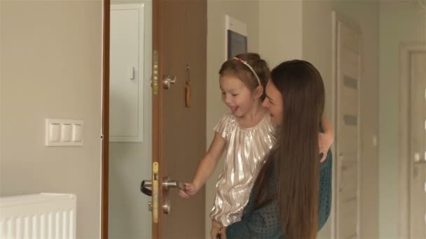 Niña y su madre conociendo a una feliz pareja de ancianos en la puerta. Abuelos visitando a su nieta — Vídeos de Stock